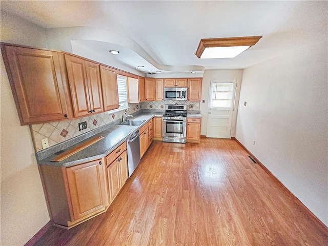 2828 School St, Harmony Twp Bea, PA 15003 - kitchen with stainless steel appliances, a sink, light wood-type flooring, backsplash, and baseboards