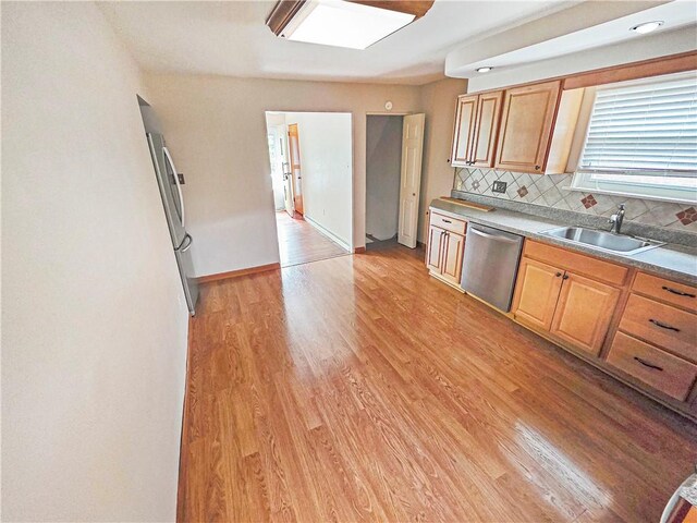 2828 School St, Harmony Twp Bea, PA 15003 - kitchen featuring appliances with stainless steel finishes, a sink, light wood-type flooring, decorative backsplash, and baseboards