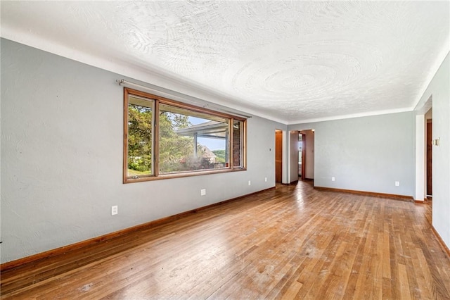 308 Cypress St, Rostraver, PA 15089 - empty room featuring a textured ceiling, light wood-style flooring, and baseboards