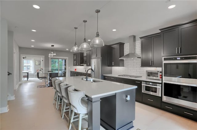 302 Highpointe Dr, Seven Fields Boro, PA 16046 - kitchen featuring wall chimney range hood, appliances with stainless steel finishes, decorative backsplash, a kitchen island with sink, and recessed lighting