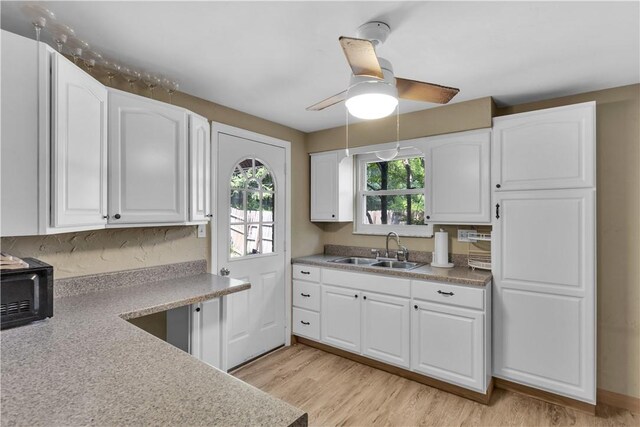 2389 High Oak Dr, Banksville/Westwood, PA 15220 - kitchen featuring a sink, a ceiling fan, white cabinetry, light wood-style flooring, and light countertops