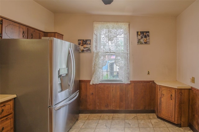 202 Jane St, Mckees Rocks, PA 15136 - kitchen featuring stainless steel fridge with ice dispenser, brown cabinetry, a wainscoted wall, wood walls, and light countertops