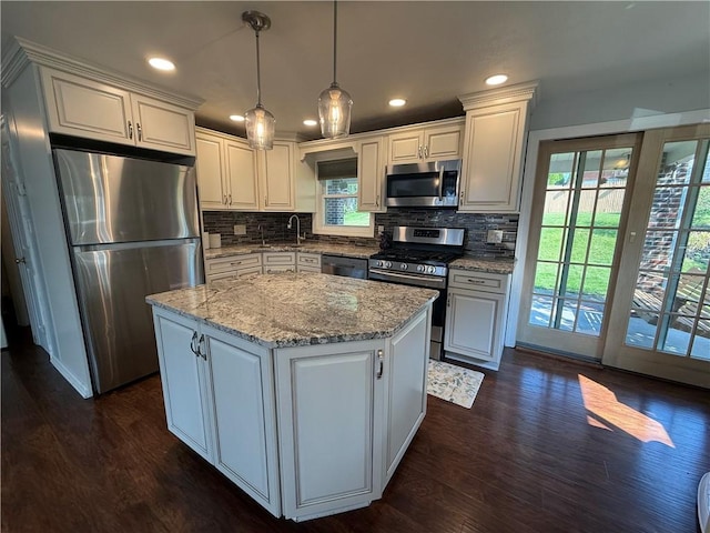 10 Claireview Dr, Carnegie, PA 15106 - kitchen with stainless steel appliances, dark wood finished floors, tasteful backsplash, a center island, and light stone counters