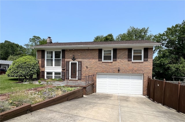 501 Clarendon St, Ohara, PA 15238 - split foyer home with an attached garage, concrete driveway, a chimney, and brick siding