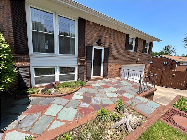 501 Clarendon St, Ohara, PA 15238 - back of property featuring an attached garage, brick siding, driveway, and a patio