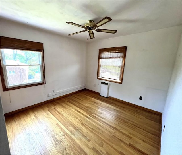 501 Clarendon St, Ohara, PA 15238 - spare room featuring radiator heating unit, light wood-style floors, ceiling fan, and baseboards