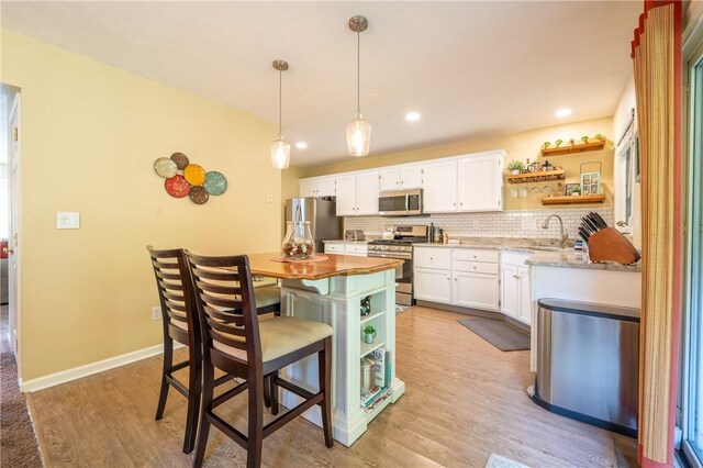 113 Unity Sq, Unity Twp, PA 15601 - kitchen featuring stainless steel appliances, open shelves, white cabinetry, decorative backsplash, and a sink