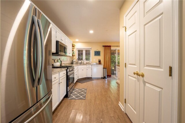 113 Unity Sq, Unity Twp, PA 15601 - kitchen with stainless steel appliances, wood finished floors, white cabinets, recessed lighting, and decorative backsplash