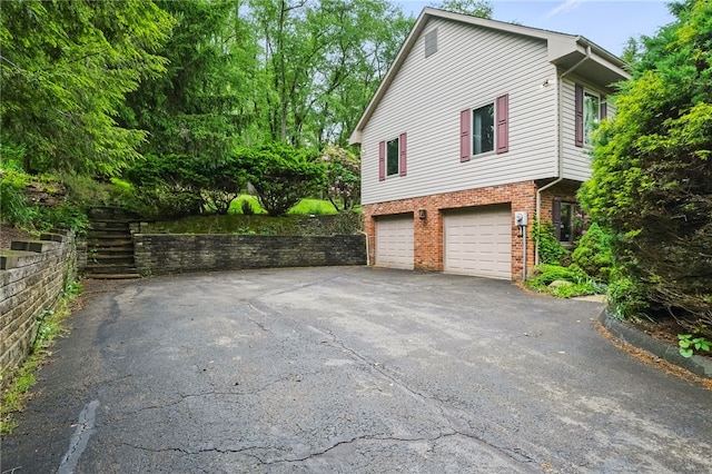 120 Canterbury Ln, Peters Twp, PA 15317 - view of property exterior featuring asphalt driveway, an attached garage, and brick siding
