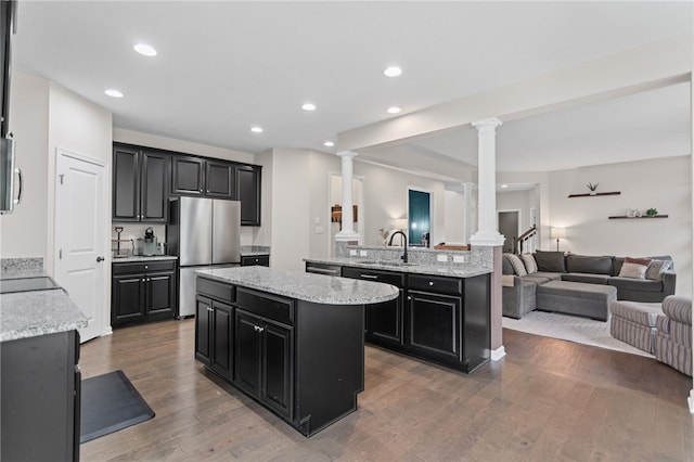 3035 Brookstone Dr, Cecil, PA 15317 - kitchen with freestanding refrigerator, ornate columns, open floor plan, a center island, and dark cabinetry