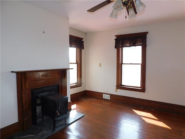 309 Mooney Ridge Rd, Waynsbrg/Frankln Twp, PA 15370 - unfurnished living room with wood finished floors, a wood stove, a ceiling fan, and baseboards