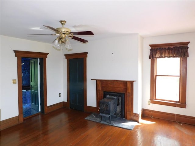 309 Mooney Ridge Rd, Waynsbrg/Frankln Twp, PA 15370 - unfurnished living room featuring a wood stove, wood finished floors, baseboards, and a ceiling fan