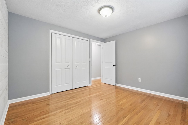 450 Limestone Dr, Bethel Park, PA 15102 - unfurnished bedroom featuring light wood finished floors, a closet, baseboards, and a textured ceiling