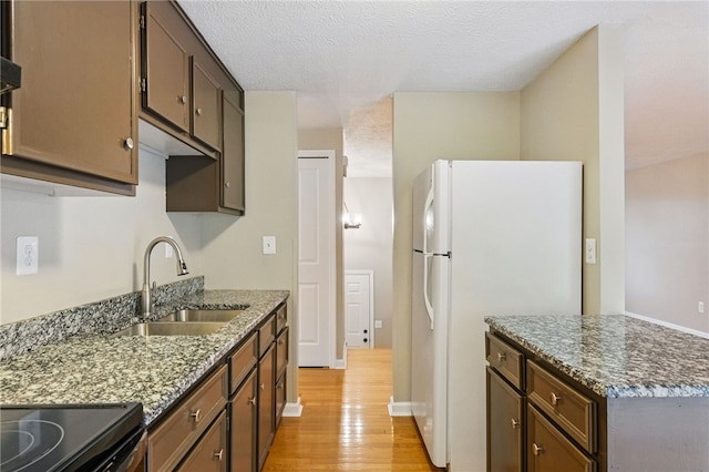 450 Limestone Dr, Bethel Park, PA 15102 - kitchen with freestanding refrigerator, a sink, light wood-type flooring, dark stone countertops, and a textured ceiling