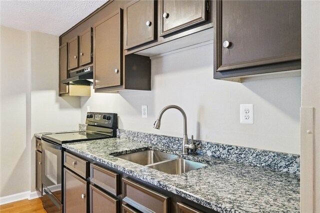450 Limestone Dr, Bethel Park, PA 15102 - kitchen with black range with electric stovetop, a sink, under cabinet range hood, light wood finished floors, and light stone countertops