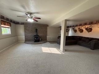 142 Poorbaugh Rd, Bullskin Twp, PA 15425 - unfurnished living room with a wood stove, carpet floors, ceiling fan, and baseboards