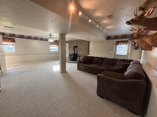 142 Poorbaugh Rd, Bullskin Twp, PA 15425 - living area featuring plenty of natural light, decorative columns, a wood stove, rail lighting, and a textured ceiling