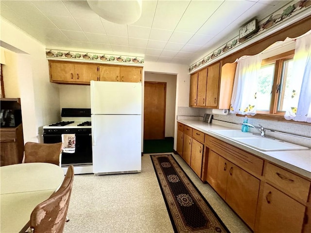 4404 Hollow Rd, Shenango Twp Law, PA 16101 - kitchen featuring freestanding refrigerator, gas stove, a sink, light countertops, and brown cabinets