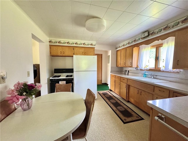 4404 Hollow Rd, Shenango Twp Law, PA 16101 - kitchen featuring freestanding refrigerator, gas range oven, a sink, light countertops, and brown cabinetry
