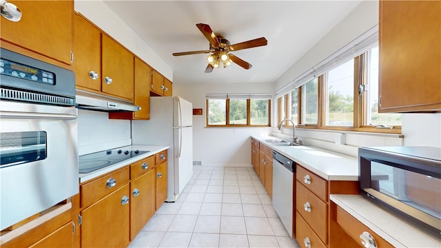 721 Herman Rd, Summit Twp But, PA 16002 - kitchen with under cabinet range hood, stainless steel appliances, a sink, brown cabinets, and light countertops
