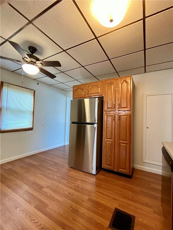 923 Fentzel, Tarentum, PA 15084 - kitchen with appliances with stainless steel finishes, baseboards, light wood-style flooring, brown cabinetry, and a paneled ceiling