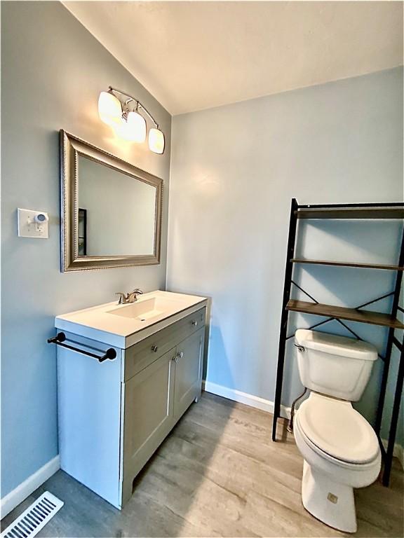 923 Fentzel, Tarentum, PA 15084 - bathroom with baseboards, toilet, vanity, and wood finished floors