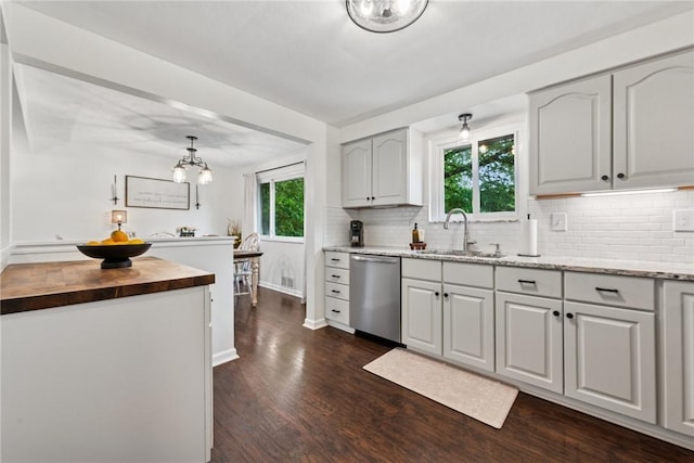 1703 Barry Dr, North Huntingdon, PA 15642 - kitchen featuring stainless steel dishwasher, a sink, butcher block countertops, dark wood-type flooring, and decorative backsplash