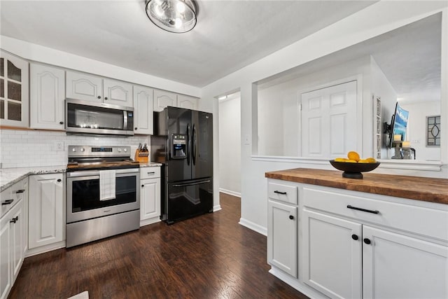 1703 Barry Dr, North Huntingdon, PA 15642 - kitchen featuring appliances with stainless steel finishes, butcher block countertops, glass insert cabinets, decorative backsplash, and dark wood-style flooring