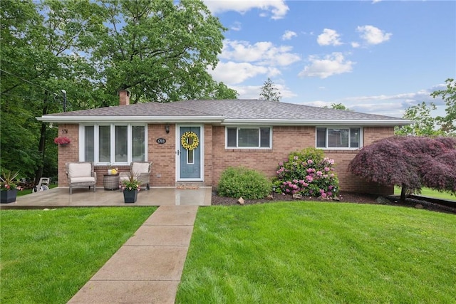 1703 Barry Dr, North Huntingdon, PA 15642 - view of front of home featuring brick siding, a front lawn, a chimney, and a patio area