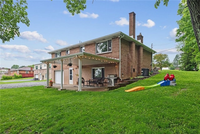 1703 Barry Dr, North Huntingdon, PA 15642 - back of house featuring a chimney, cooling unit, brick siding, a lawn, and a patio area