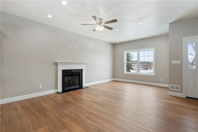480 Matty, Rostraver, PA 15012 - unfurnished living room with healthy amount of natural light, a ceiling fan, a fireplace with raised hearth, light wood-style floors, and recessed lighting