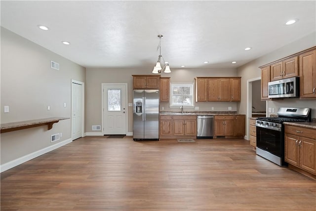 480 Matty, Rostraver, PA 15012 - kitchen featuring stainless steel appliances, a sink, wood finished floors, brown cabinets, and recessed lighting