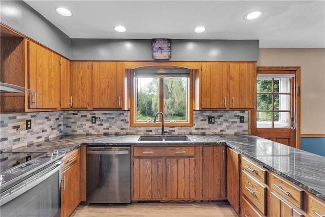 206 Brook Hollow Rd, Pa, PA 15666 - kitchen with appliances with stainless steel finishes, a sink, brown cabinetry, light wood-style floors, and dark stone countertops