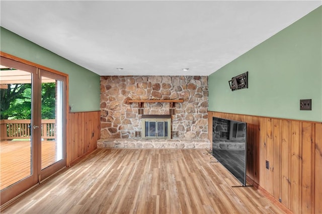 206 Brook Hollow Rd, Pa, PA 15666 - unfurnished living room with a stone fireplace, a wainscoted wall, wood finished floors, and wooden walls