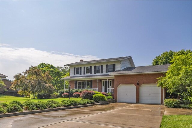 206 Brook Hollow Rd, Pa, PA 15666 - view of front facade featuring driveway, an attached garage, covered porch, and brick siding