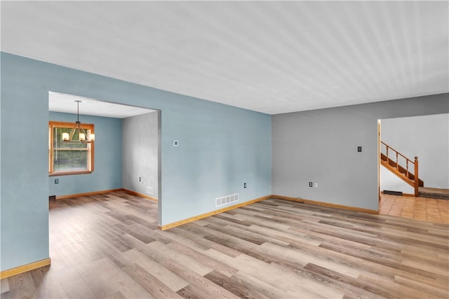 206 Brook Hollow Rd, Pa, PA 15666 - unfurnished living room with a chandelier, wood finished floors, and baseboards