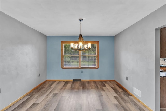 206 Brook Hollow Rd, Pa, PA 15666 - unfurnished dining area with a chandelier, wood finished floors, and baseboards