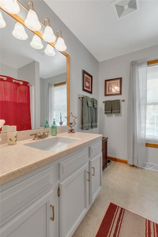 117 Bayberry Ln, Cranberry Twp, PA 16066 - bathroom with vanity, healthy amount of natural light, tile patterned floors, and baseboards