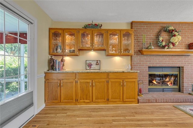117 Bayberry Ln, Cranberry Twp, PA 16066 - bar featuring light wood-style floors, plenty of natural light, a textured ceiling, and a brick fireplace