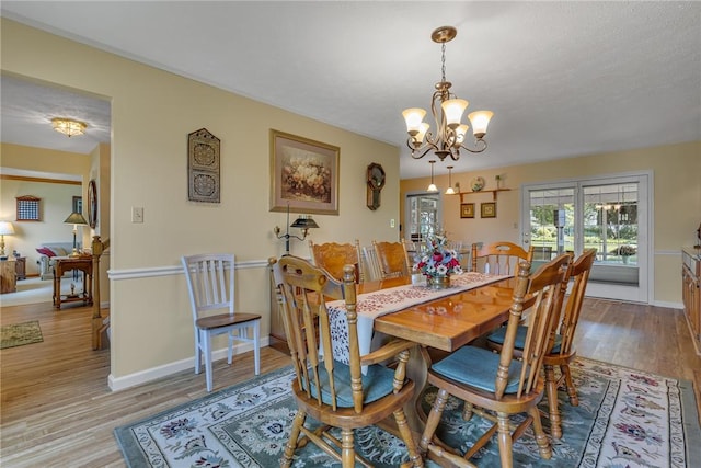 117 Bayberry Ln, Cranberry Twp, PA 16066 - dining room featuring a chandelier, wood finished floors, and baseboards