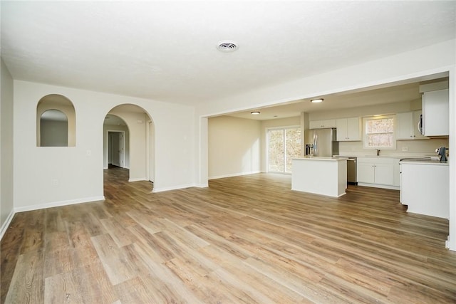 2596 Tilbrook Rd, Monroeville, PA 15146 - unfurnished living room with light wood finished floors, baseboards, and a sink