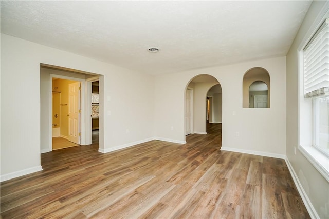 2596 Tilbrook Rd, Monroeville, PA 15146 - unfurnished room featuring light wood-style floors, arched walkways, and baseboards