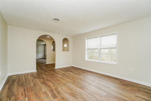 2596 Tilbrook Rd, Monroeville, PA 15146 - unfurnished room with light wood finished floors, arched walkways, and baseboards