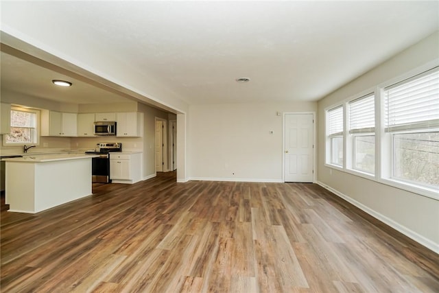 2596 Tilbrook Rd, Monroeville, PA 15146 - unfurnished living room with wood finished floors, baseboards, and a sink