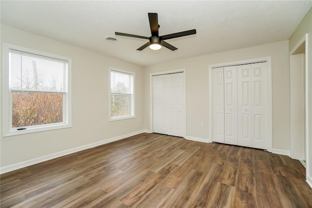 2596 Tilbrook Rd, Monroeville, PA 15146 - unfurnished bedroom featuring multiple closets, wood finished floors, baseboards, and a ceiling fan