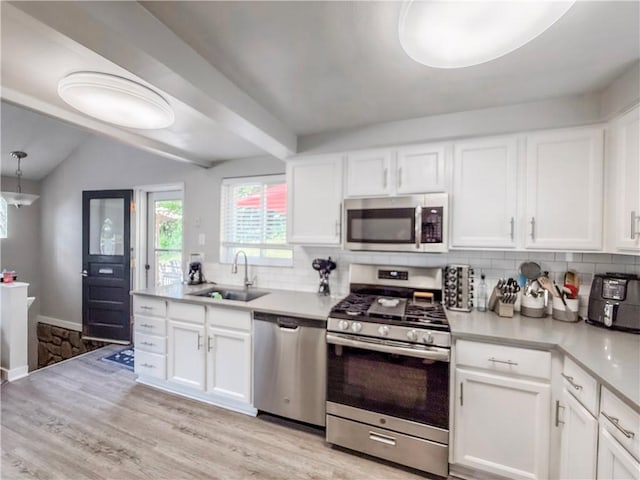 2787 Queensboro Ave, Baldwin Twp, PA 15226 - kitchen featuring appliances with stainless steel finishes, a sink, tasteful backsplash, light wood-type flooring, and vaulted ceiling
