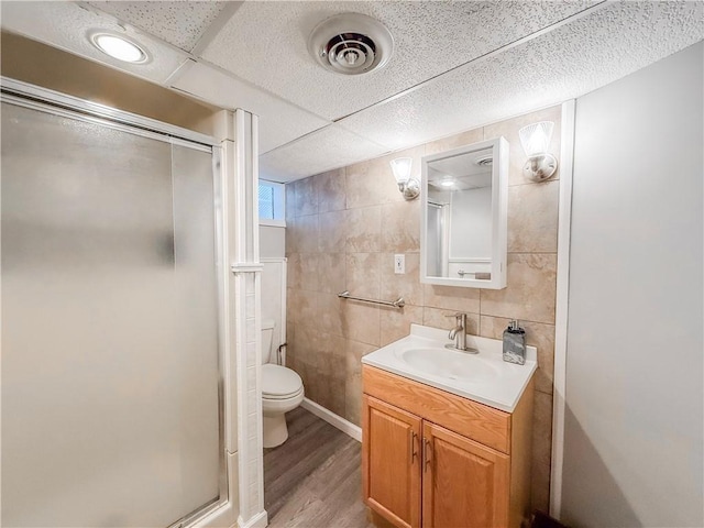 2787 Queensboro Ave, Baldwin Twp, PA 15226 - full bathroom featuring a stall shower, vanity, toilet, tile walls, and wood finished floors