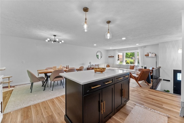 2406 Rolling Farms Rd, Shaler, PA 15116 - kitchen featuring open floor plan, light countertops, a kitchen island, light wood-type flooring, and a textured ceiling