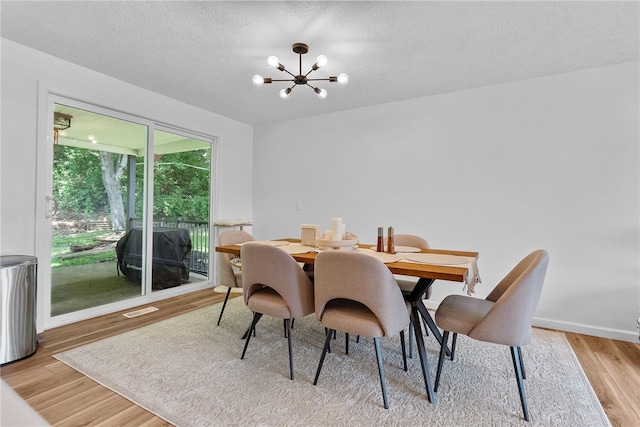 2406 Rolling Farms Rd, Shaler, PA 15116 - dining room with a chandelier, light wood-style flooring, a textured ceiling, and baseboards
