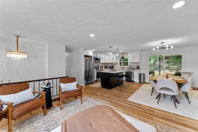 2406 Rolling Farms Rd, Shaler, PA 15116 - living room with a chandelier, light wood-style flooring, a textured ceiling, recessed lighting, and baseboards